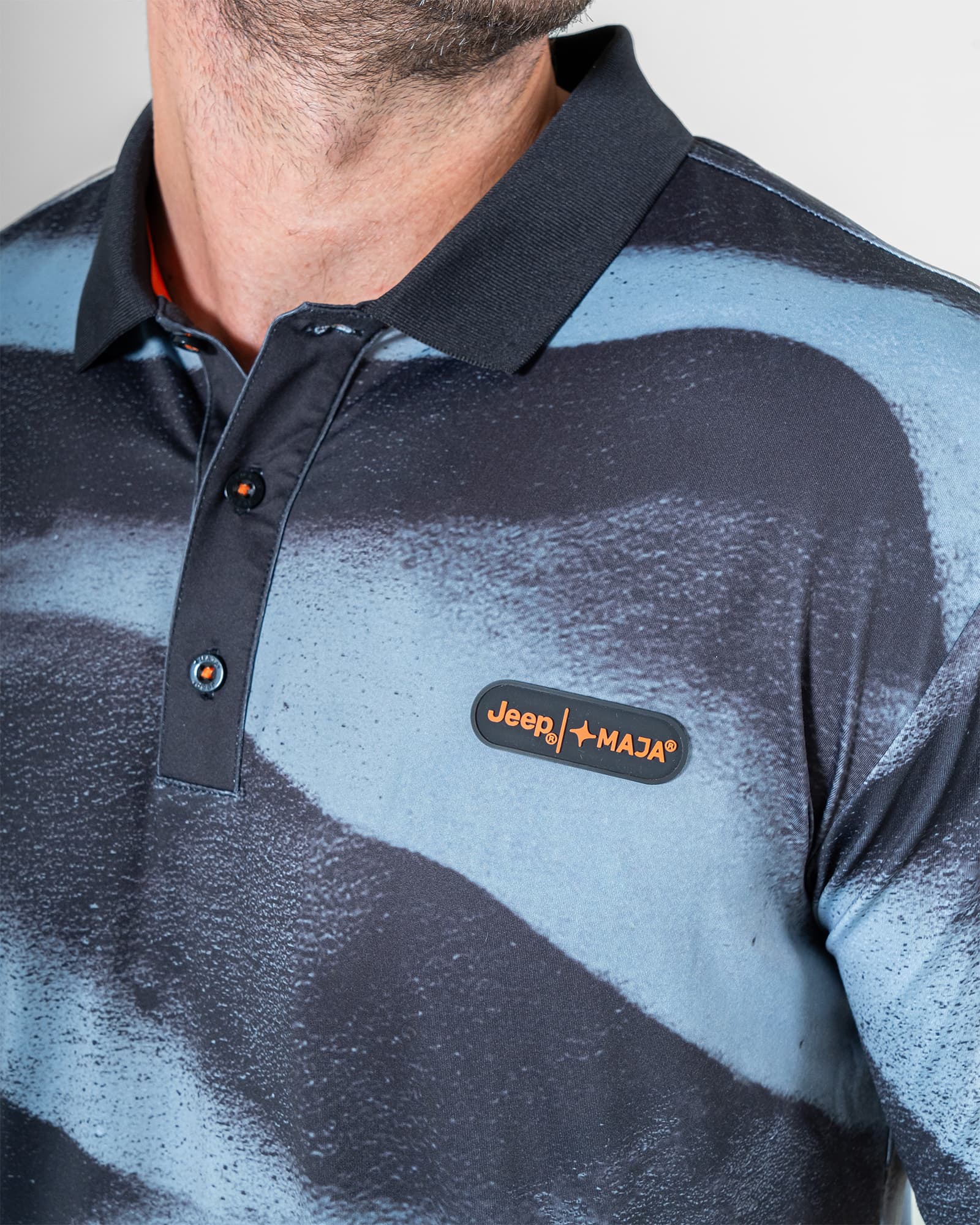 Polo Dri Fit JEEP® x MAJA®Jeepster, Patrón duna negro, vista lateral, fit Regular, Poliéster, con Tela estiramiento 4 vías, uso versátil